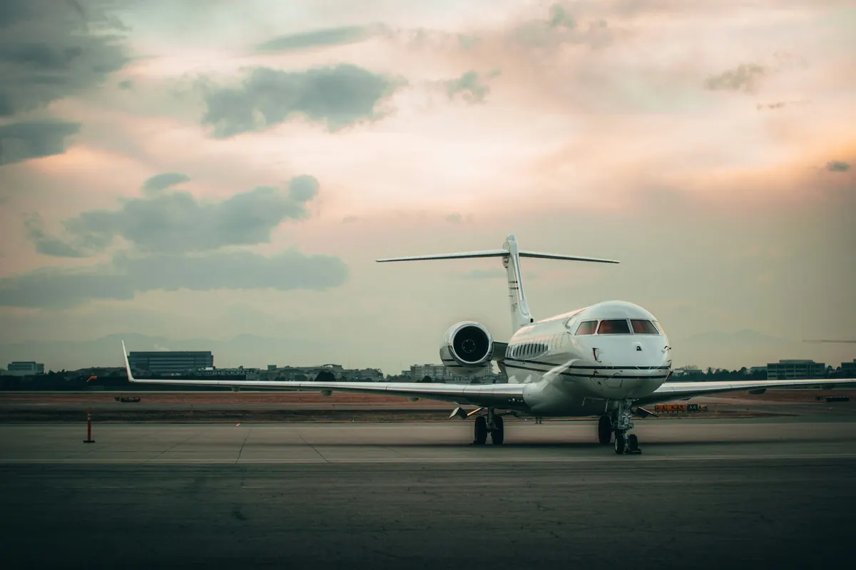 Long-range business jet parked on the ramp under a soft dusk sky