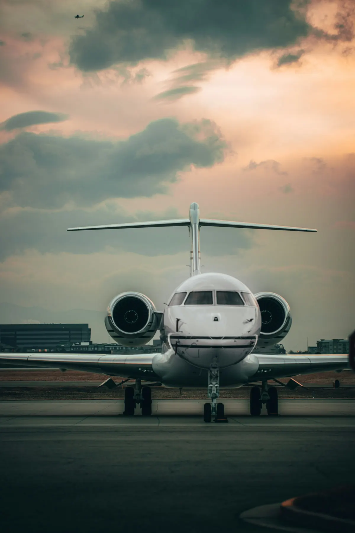 Long-range business jet facing the camera on an apron under evening cloud