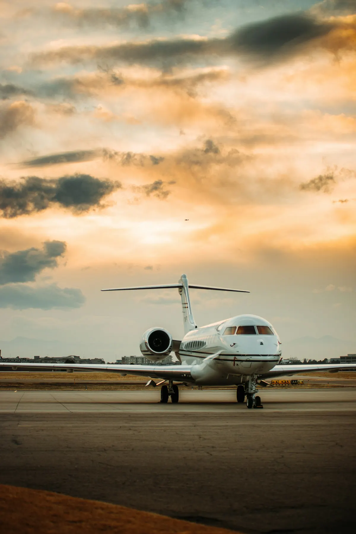 Business jet parked on the ramp under a golden evening sky